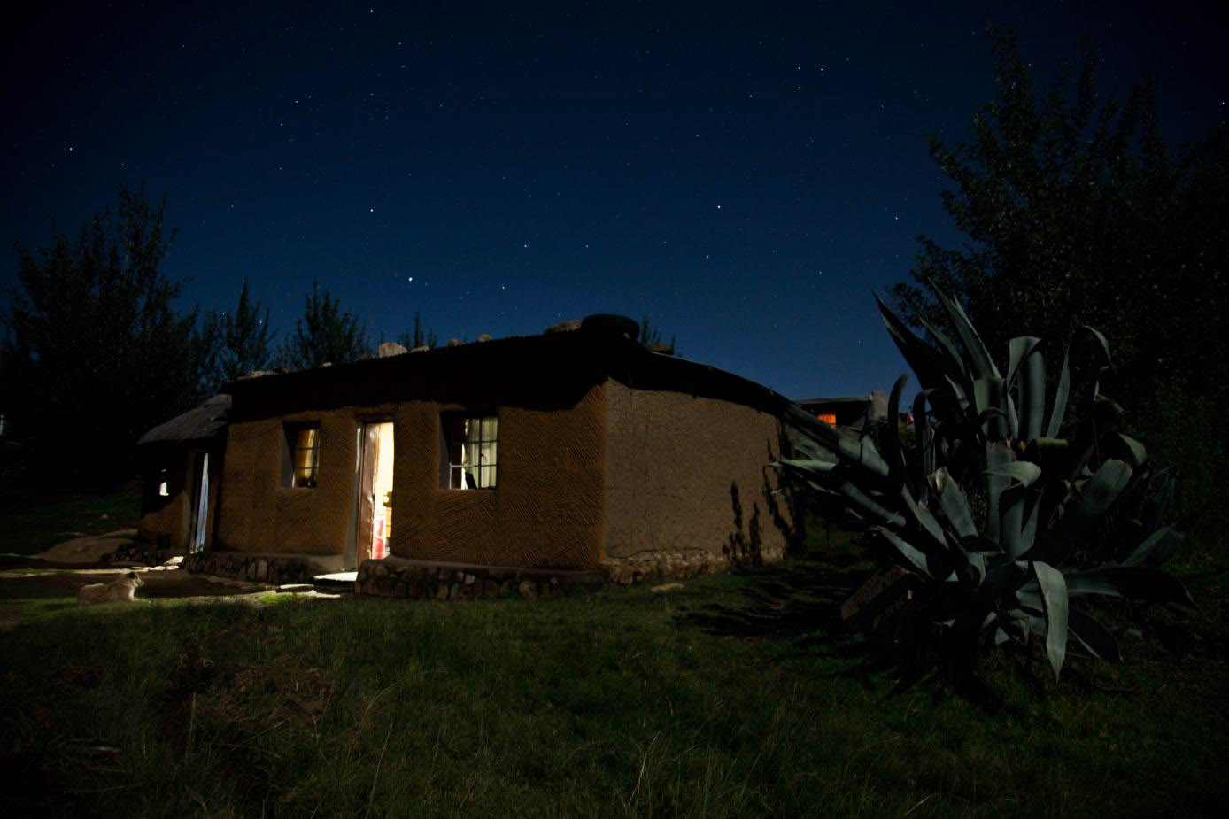 Eine erleuchtete Hütte unterm Sternenhimmel in Lesotho